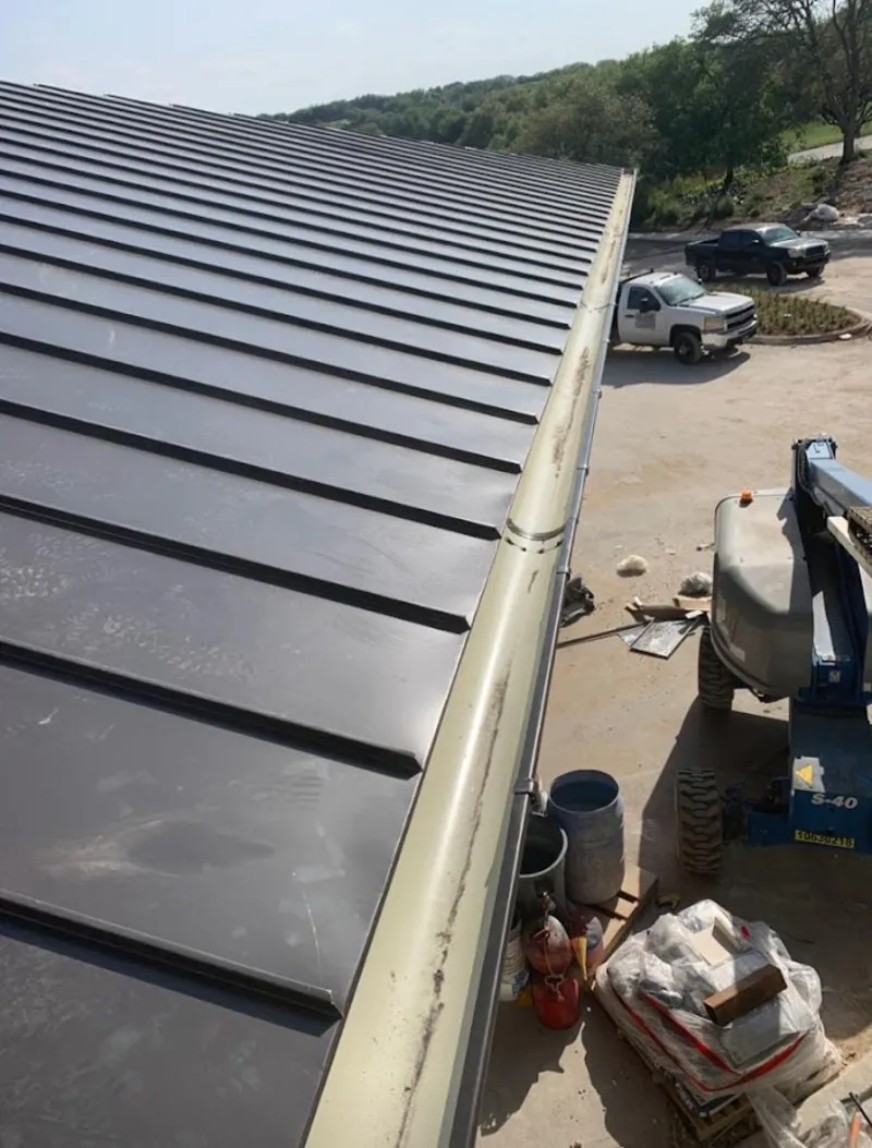 Standing seam panel and gutter detail on a metal roofing jobsite in East Flat Rock